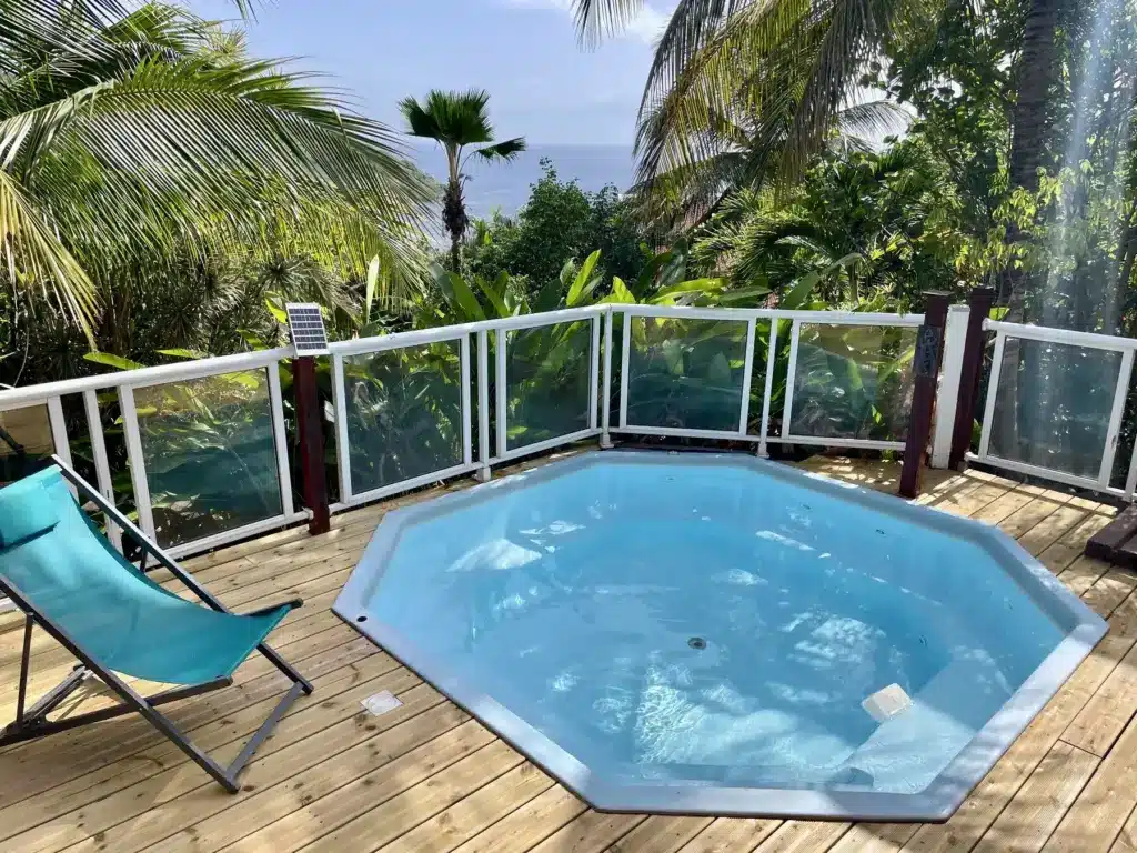 Piscine entourée de transats et de végétation tropicale